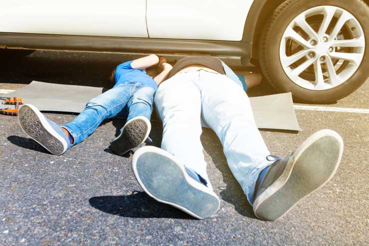 Padre e figlio sistemano l'auto (Depositphotos foto)