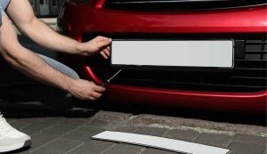 Persona che cambia la targa dell'auto